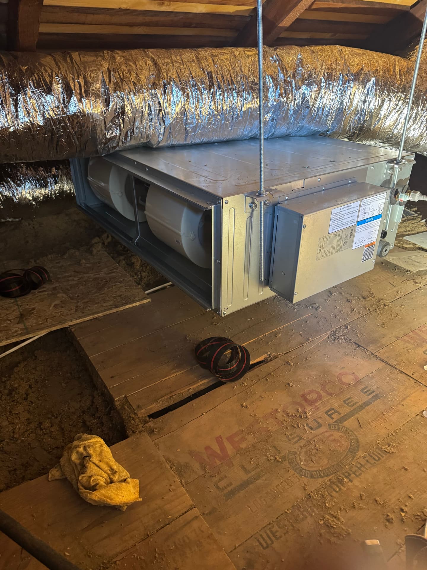 Suspended air handler installed in an attic with insulated supply duct